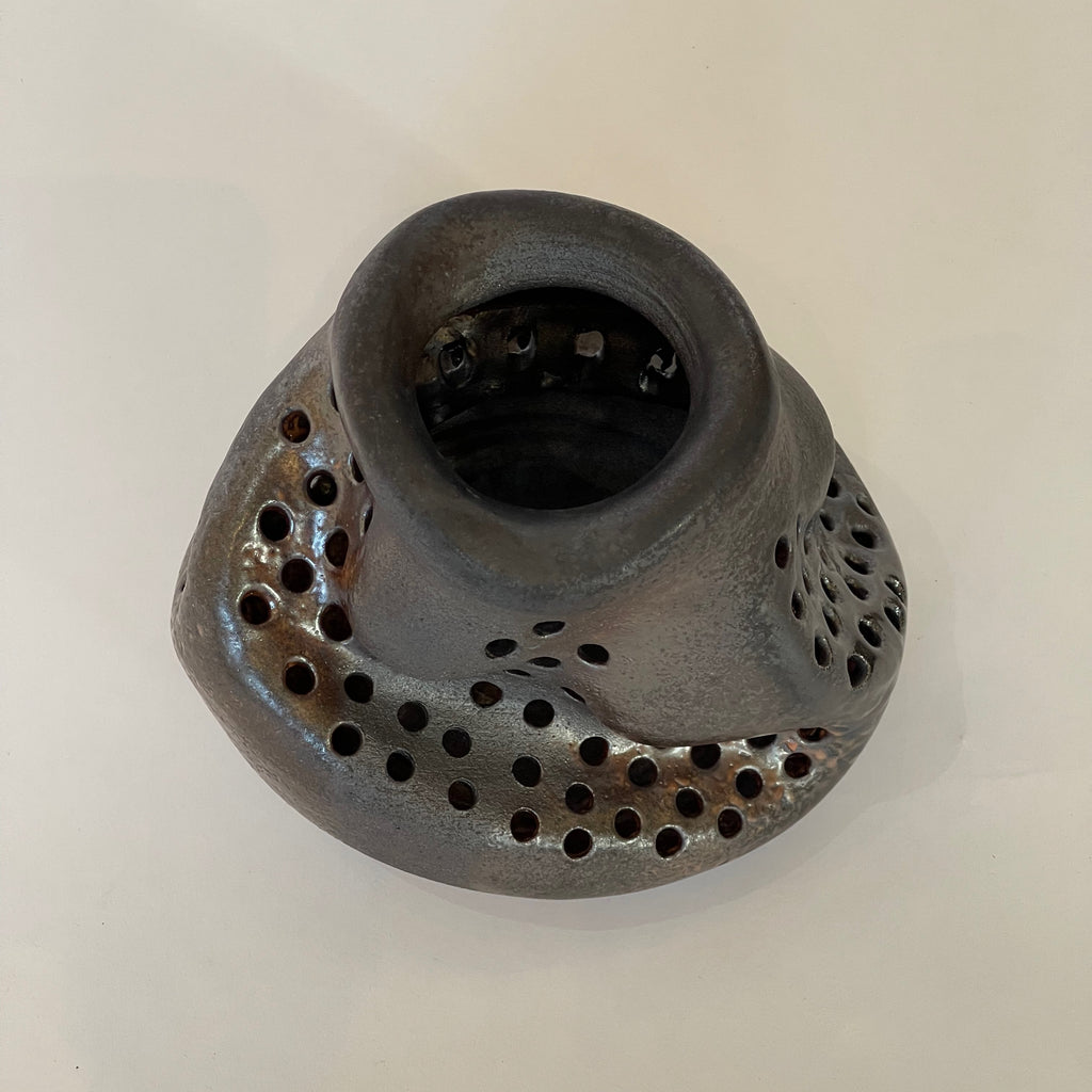 This one-of-a-kind wood fired black wave vase by Ian Hazard Bill has a gorgeous metallic glaze and drilled holes. top view