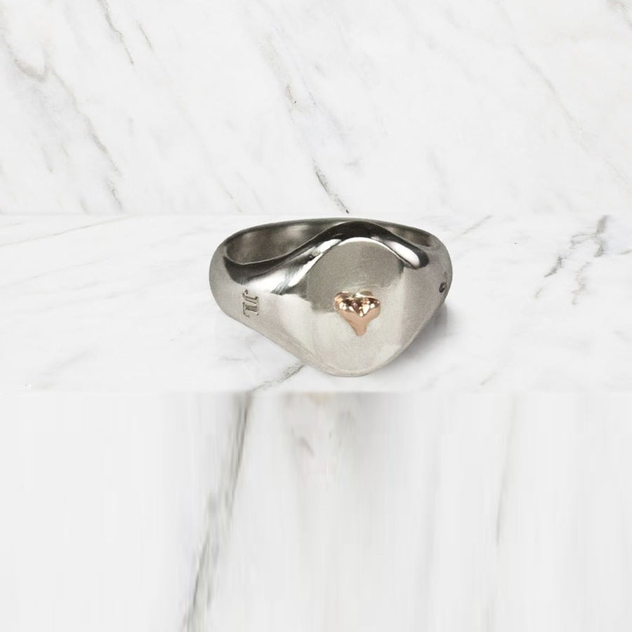 Jeffrey reimagines the classic Signet Ring, reworking it with feminine lines and using it as a canvas for other pretty things, like this contrasting tiny heart charm adornment in 14K rose gold. 