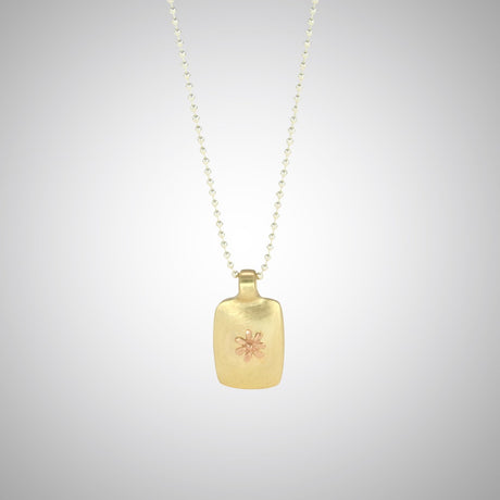 Jeffrey reimagined the classic dog tag into a modern canvas, both refined and a bit edgy. He loves mixing metals and embellished this 14k yellow gold dog tag with a contrasting 14K rose gold tiny flower charm