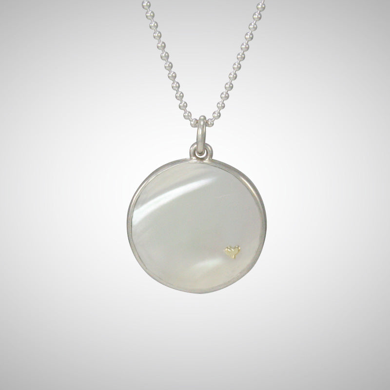 We love the luminescent white mother of pearl pendant embellished with Jeffrey's signature tiny 14K yellow gold heart charm, pinned through the shell. 