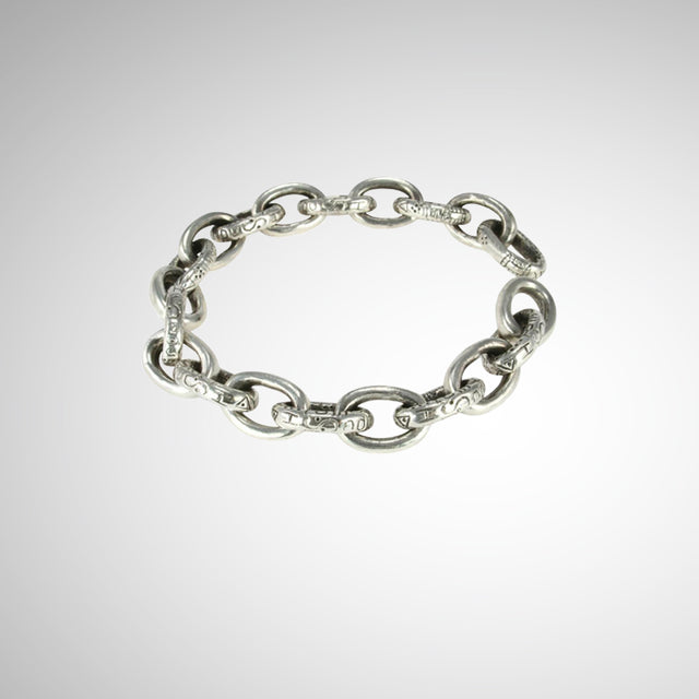 Designed and hand carved by Jeffrey Levin, Poet and/the Bench co-founder and goldsmith, this thick silver, oval chain link bracelet is yours to stack or stun on its own. The engraved oval links are finished with an architectural joint clasp system that seamlessly fit together. Edgy, yet timeless chain link jewelry.