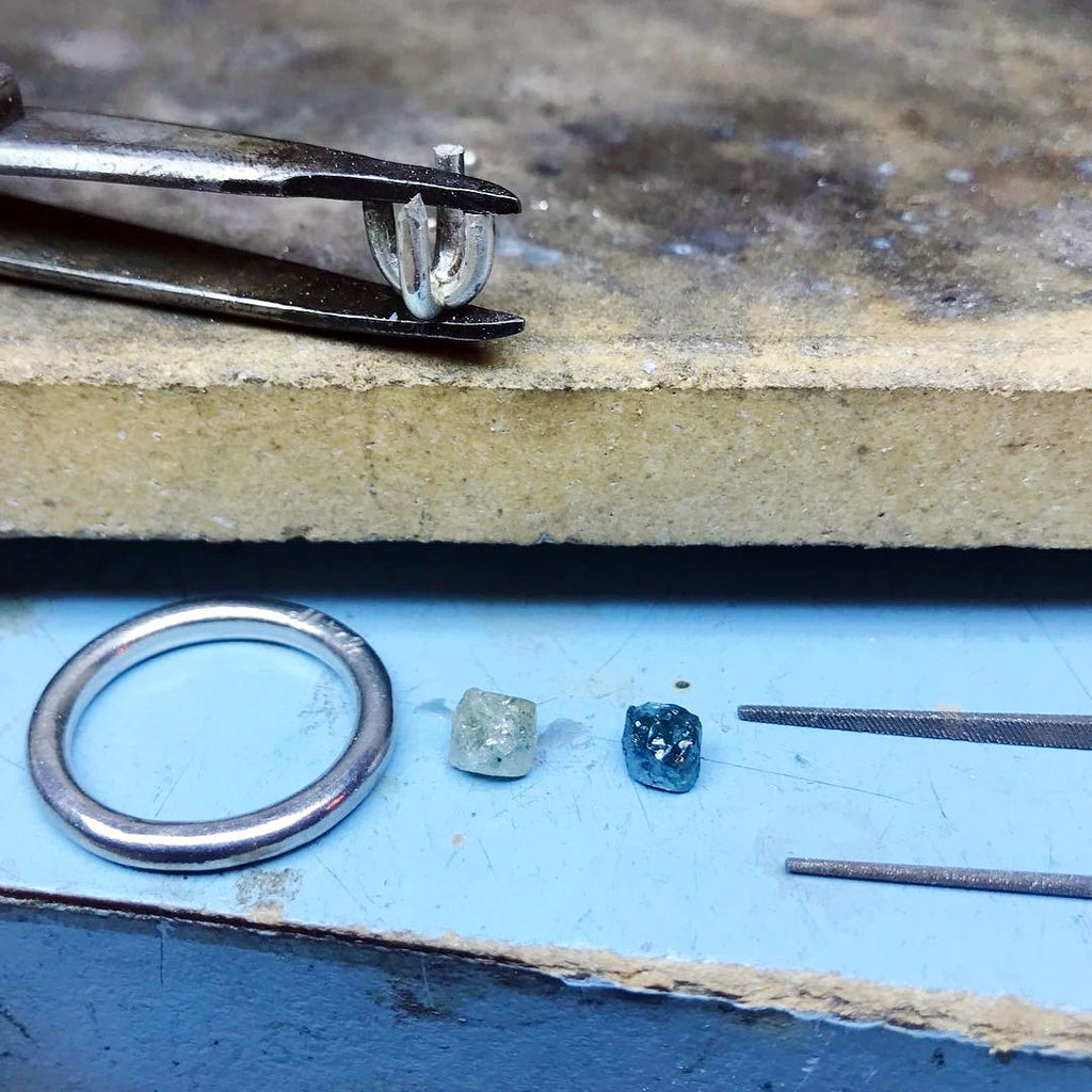 Rough diamond ring settings and rough diamonds in the process of production.