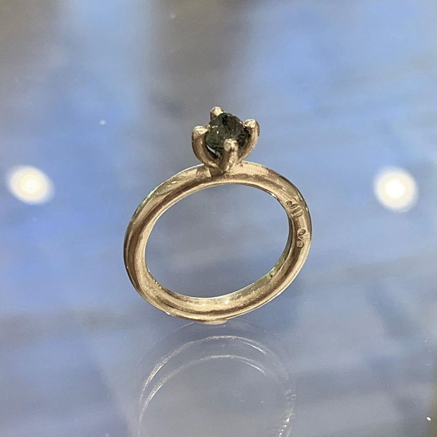 A different style of engagement ring with a rough octahedron black diamond in a thick prong setting. Designed by Jeffery Levin for a more edgy aesthetic. Shown with a nearly black octahedron diamond. 