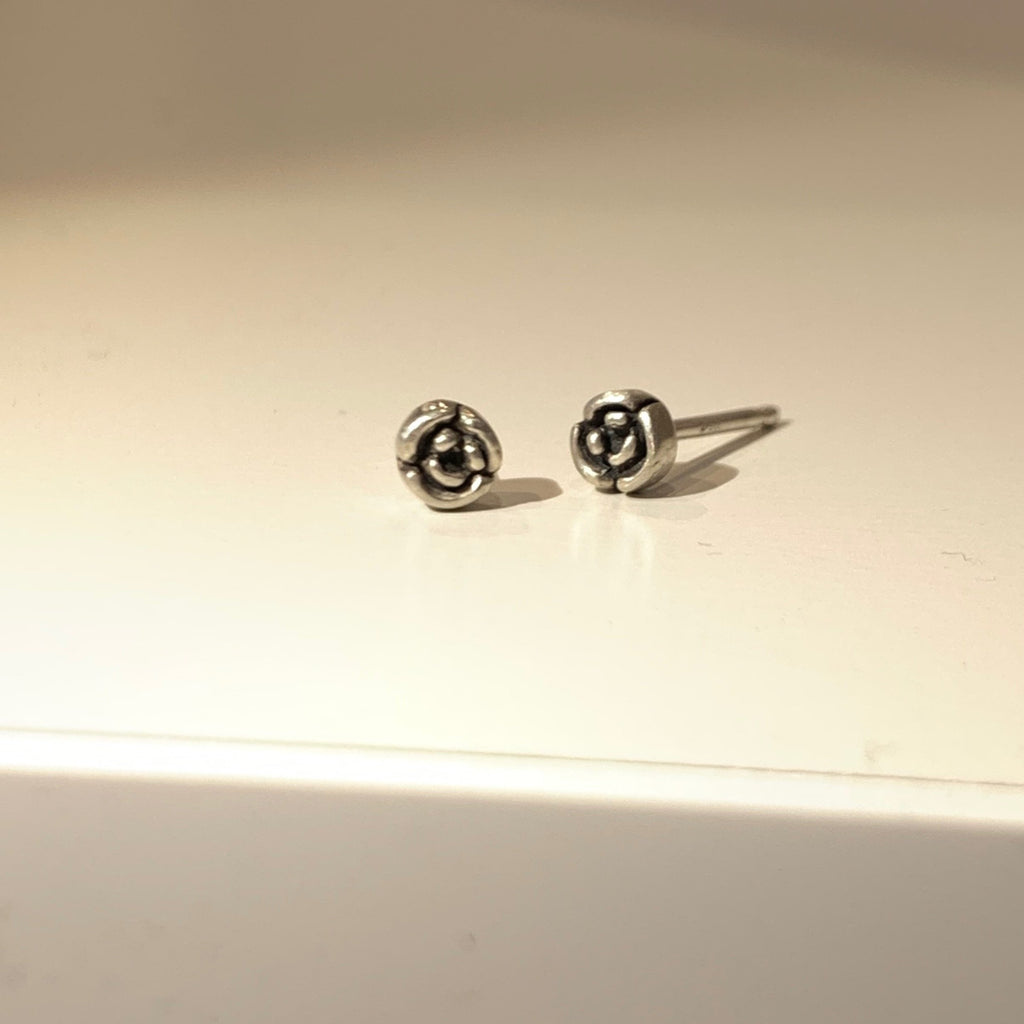 Tiny earrings carved by hand in wax before being cast in precious metals. Jeffrey's mom was named Rosette, these perfect little roses are an homage to her, all moms and rose lovers. 