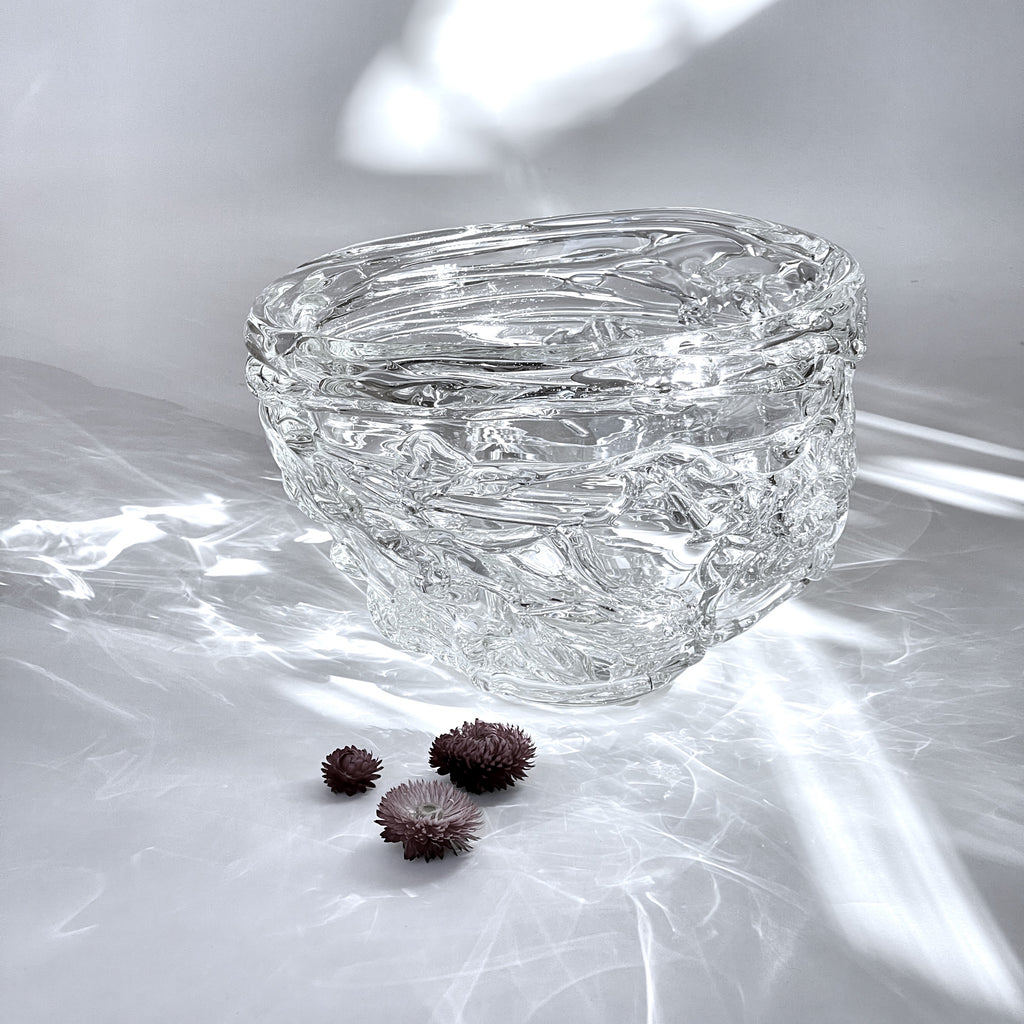 An extraordinary XL glass bowl that incorporates thick strands of glass in a wavy, Fluid design that captures and reflects light by artist Jennifer Morgan. front view