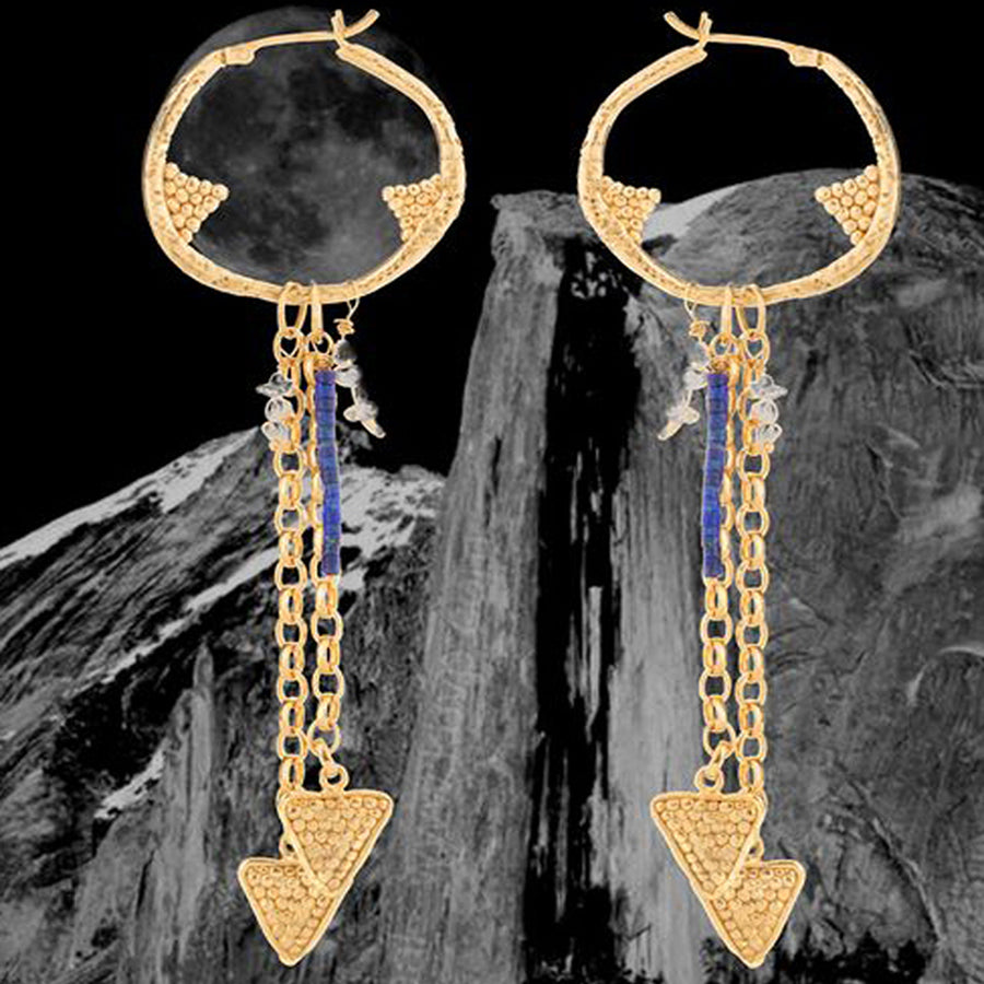A flying arrow merging with a future magic. Arrows of possibility, formed from velvet light, ride the restless winds of our longing. The Regal Arcus dangling hoop is embellished with arrows, deep ocean pearls for depth, and mountain lapis for height. 