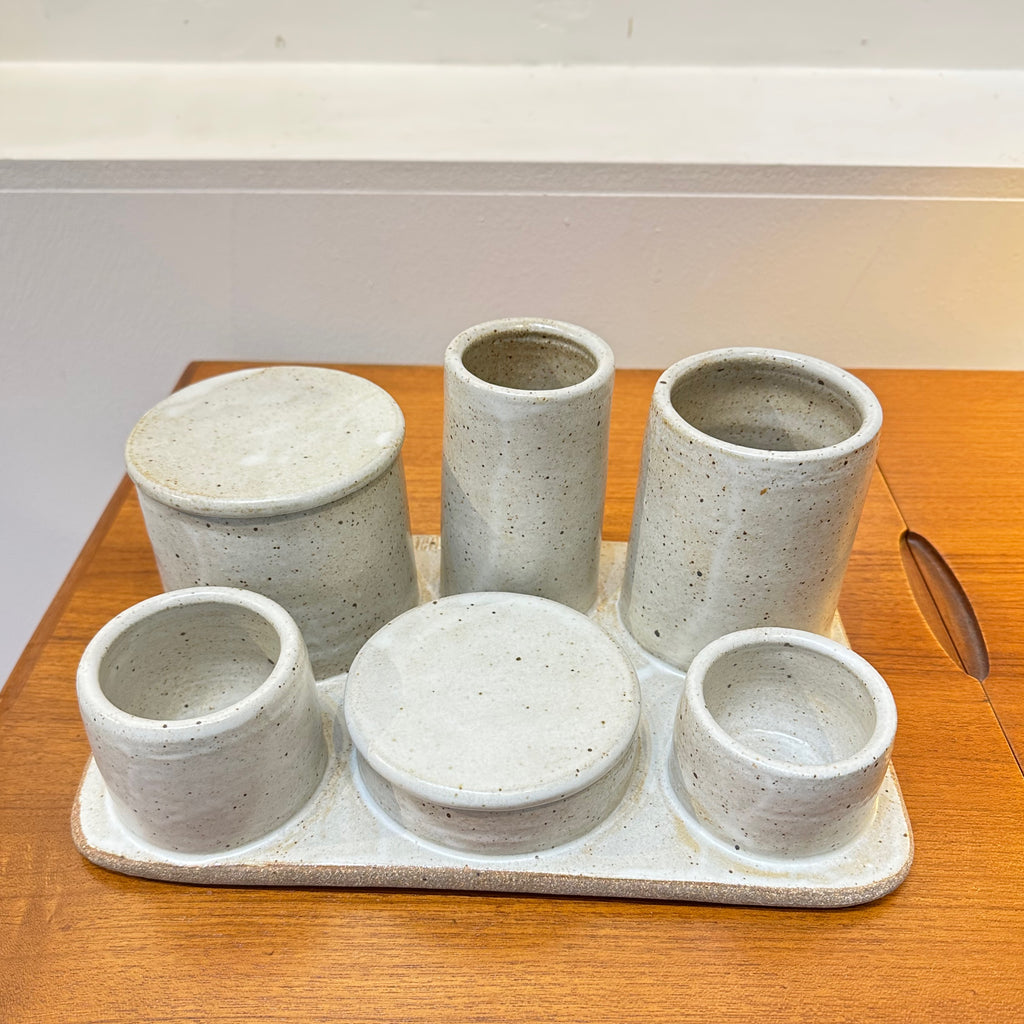 An innovative hand built ceramic organizer tray design with various sized containers; some have lids and others do not. 