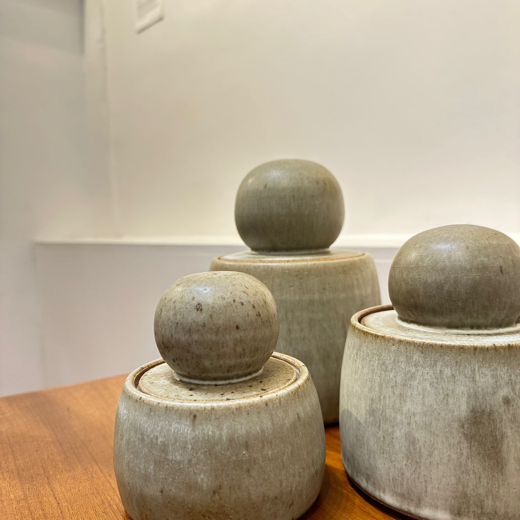 A most stylish ceramic canister with a gotta-touch-me chubby orb lid is your new fave to store everyday things. A trio of stash jars in forest, a milky glaze with hare's fur.
