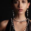 A pair of Baroque pearls clasped within textured and oxidized silver prongs that create a flow to which the eye is drawn to the end point of each earring.