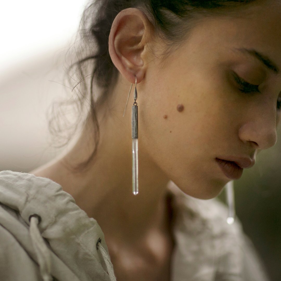 Subtle, elegant and streamlined bold. Mariella's Wand earrings are designed using a crystal point embraced in etched silver, which captures the crystal point crested by a heron’s neck. On model.