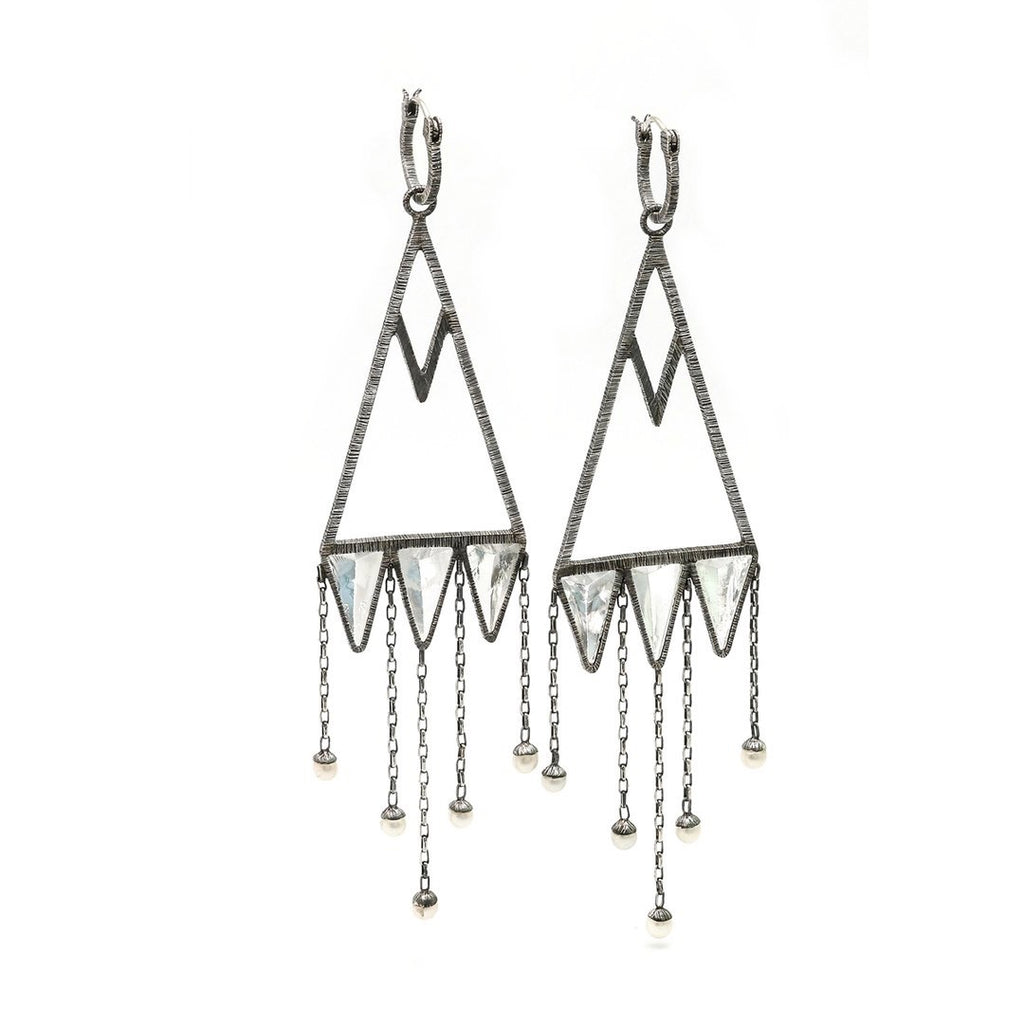 These are Mariella's stunning version of chandelier earrings. Rough-hewn rock crystals are cased in etched and oxidized silver to create capture points for hanging pearl raindrops. Angle view.