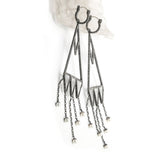 These are Mariella's stunning version of chandelier earrings. Rough-hewn rock crystals are cased in etched and oxidized silver to create capture points for hanging pearl raindrops. Side view.