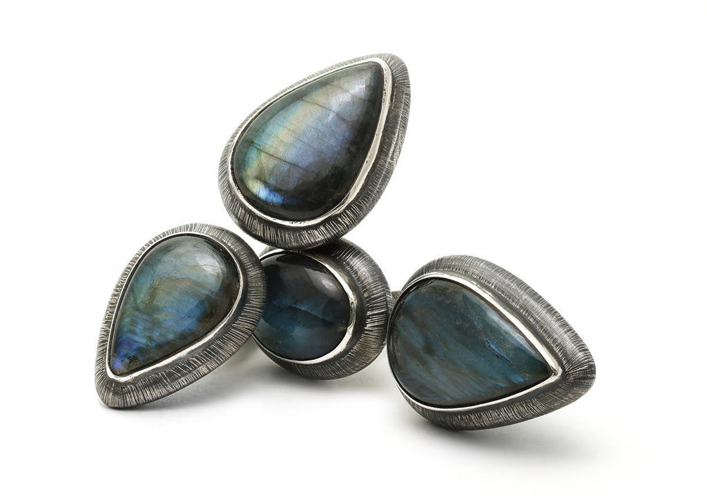 Two Rings. 1 with Oval and angular labradorite stones and the other with 2 angular labradorite stones. Set in etched and oxidized sterling silver by Mariella Pilato.