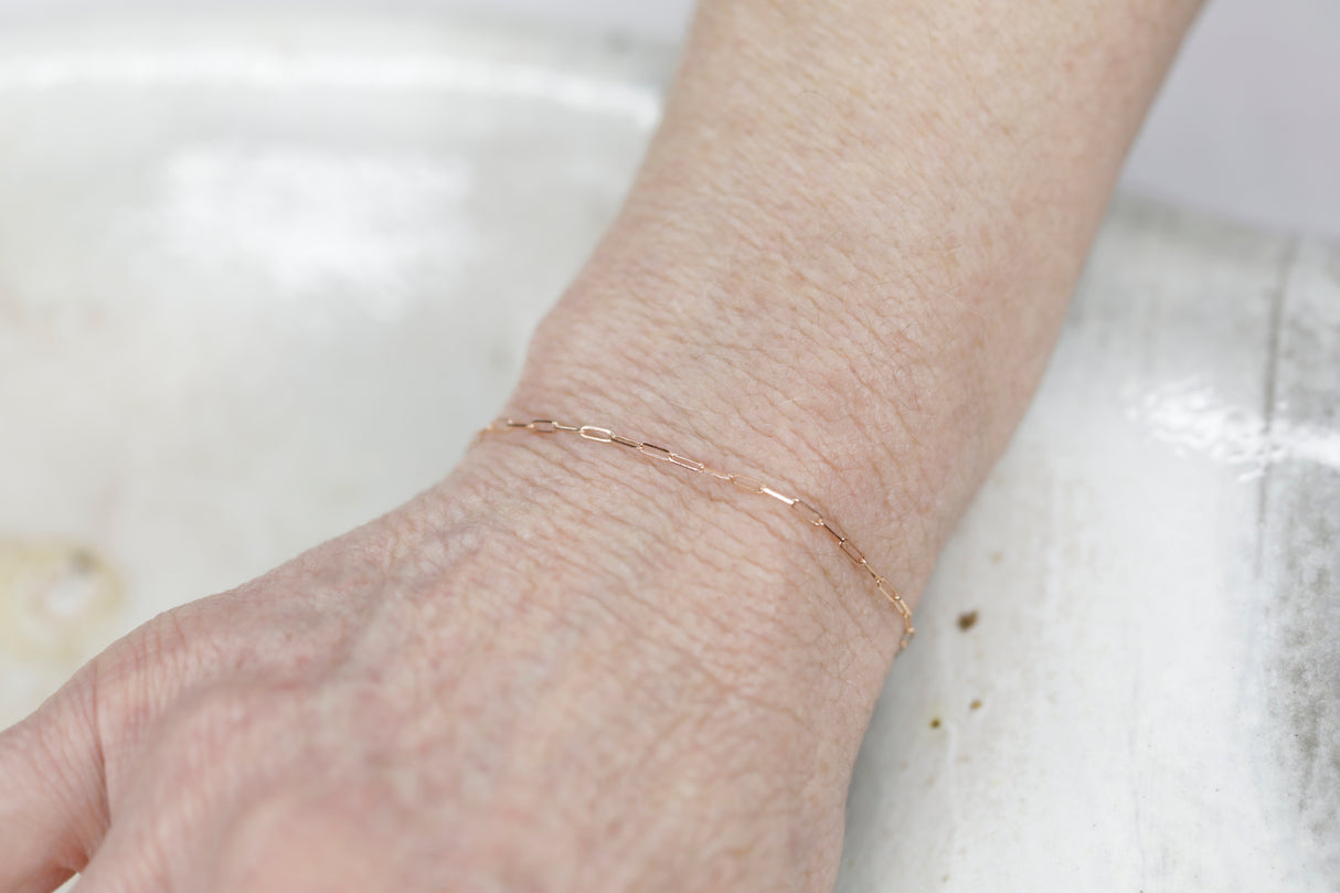 Permanent Jewelry Micro Paperclip Chain Link Bracelet shown on Bonnie's hand. Get Linked at Poet and/the Bench in Mill Valley. Together Permanent Jewelry for a Special Link to Yourself and Others at Poet and the Bench.
