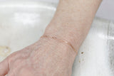 Permanent Jewelry Micro Paperclip Chain Link Bracelet shown on Bonnie's hand. Get Linked at Poet and/the Bench in Mill Valley. Together Permanent Jewelry for a Special Link to Yourself and Others at Poet and the Bench.