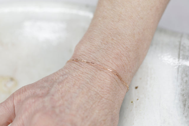 Permanent Jewelry Micro Paperclip Chain Link Bracelet shown on Bonnie's hand. Get Linked at Poet and/the Bench in Mill Valley. Together Permanent Jewelry for a Special Link to Yourself and Others at Poet and the Bench.