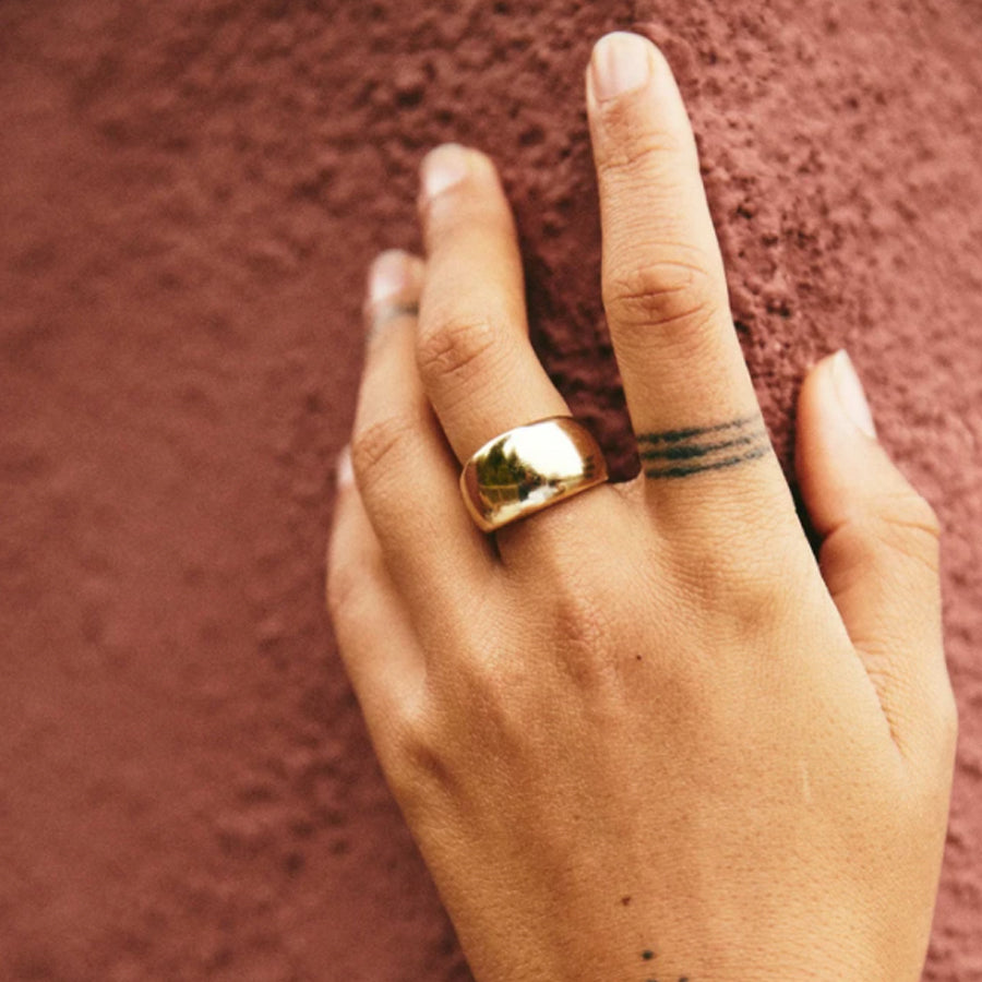 Flat domed Mira ring by Roam Vintage curator Natasha Garrett shown in Brass on model hand.