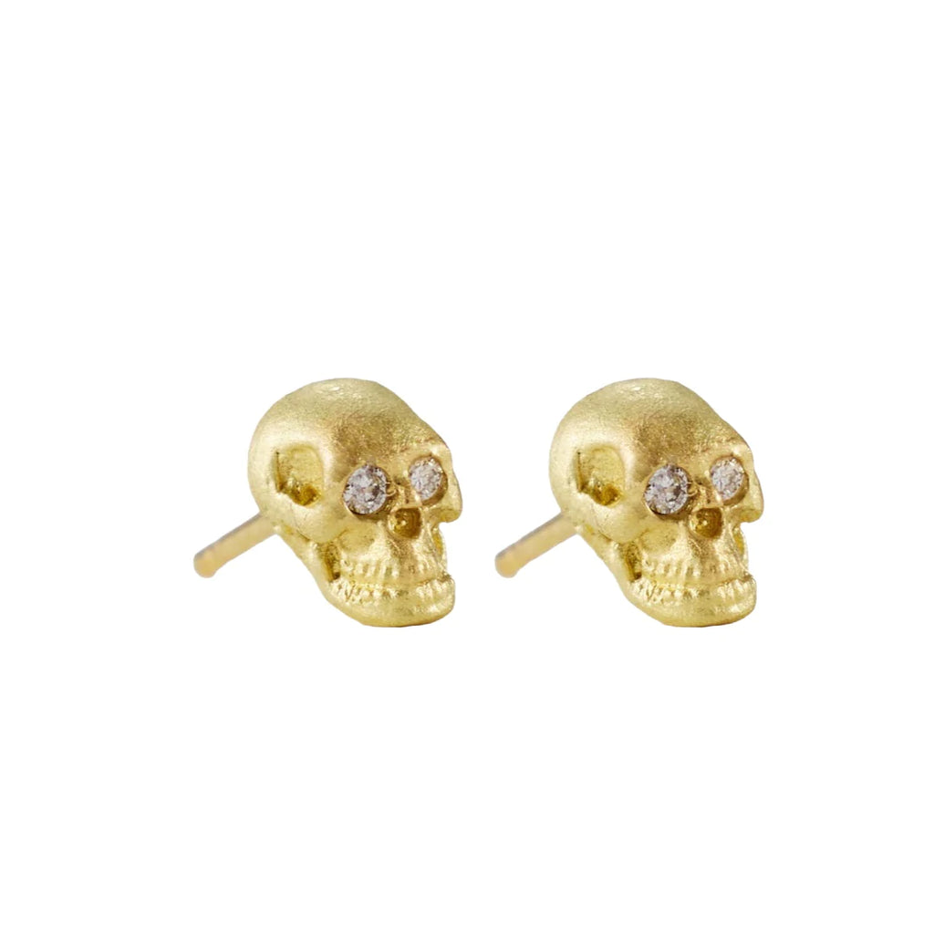 Solid, three dimensional hand carved Skull stud earrings in 18k yellow gold with a matte finish and sparkling white diamond eyes. 