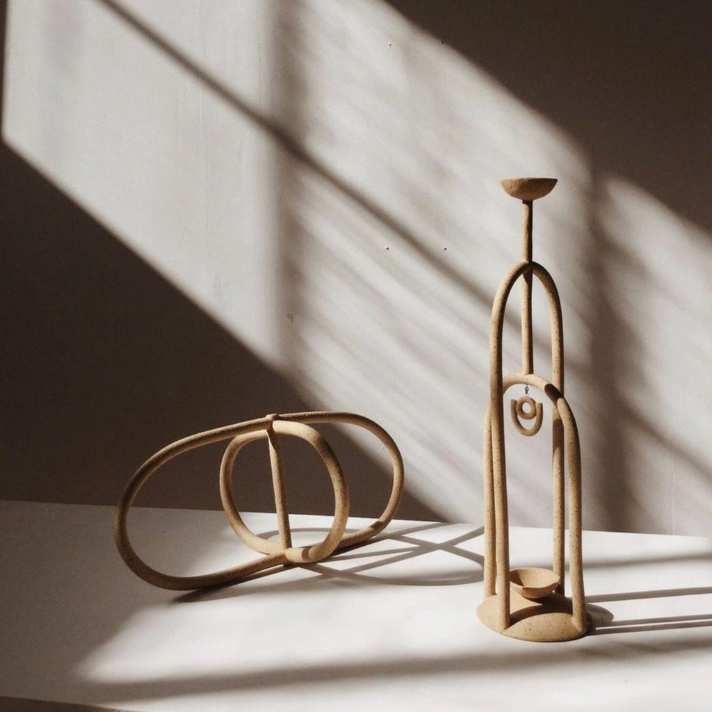 Coil-built elegance in a minimalist sculpture and Ruby candelabra.