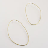 Asymmetrical oval olive-shaped brass earring hoops boast a sophisticated yet modern aesthetic. 