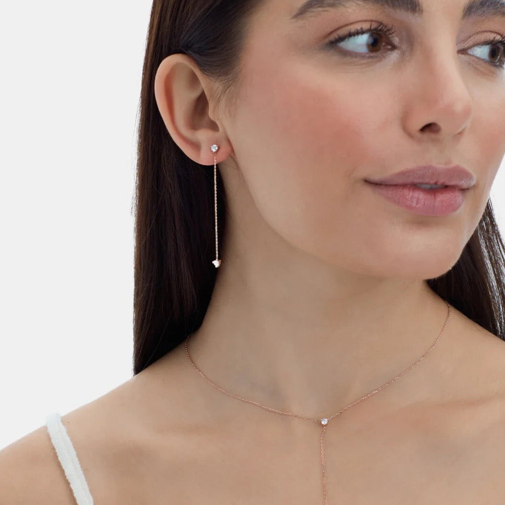 Elegant 14K gold studs feature 2 diamonds on each earring –one at the tip and one at the bottom of the chain– and 5.8mm of hanging chain that add extra dimension and a fierce style. On Model 